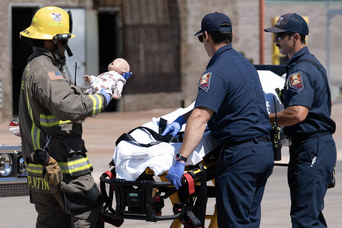 Firefighter Mike Plantin brings a baby doll to paramedics during a simulation of a child left i ...