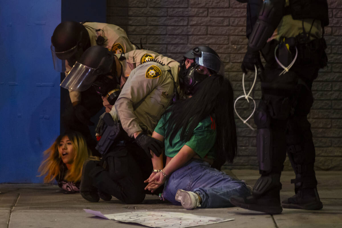Las Vegas police officers detain people protesting against ICE at Fremont Street and Maryland P ...