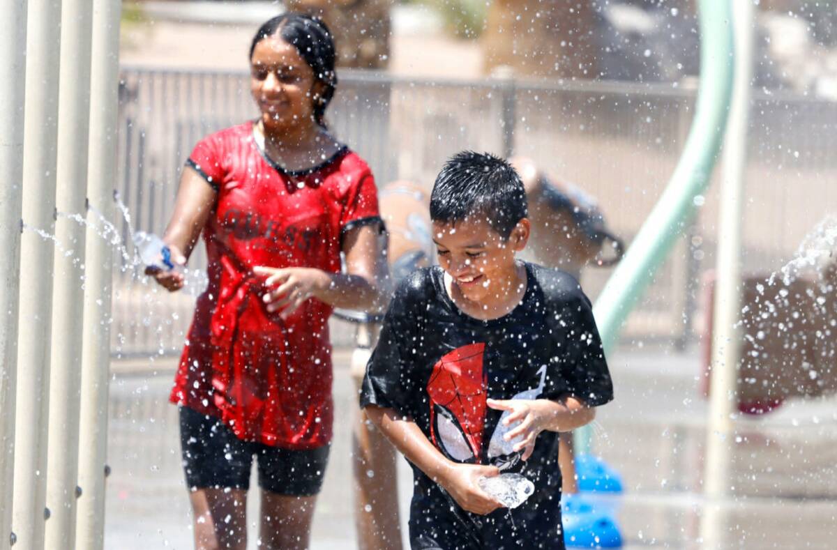Jose Martinez, 10, plays with his sister Denise Martinez, 12, at Lorenzi Park during a hot Mond ...