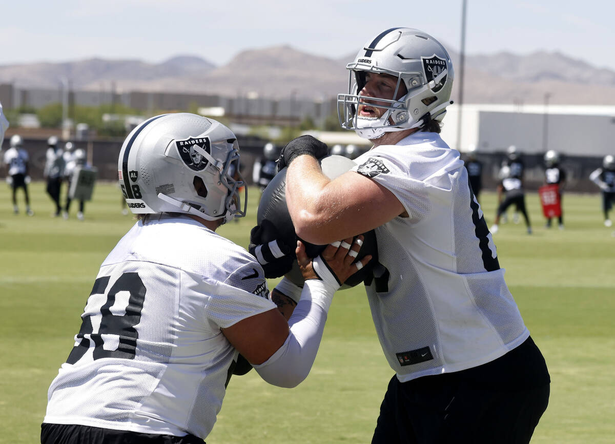 Raiders center Jackson Powers-Johnson (58) and guard Alex Cappa, right, work on drills during t ...