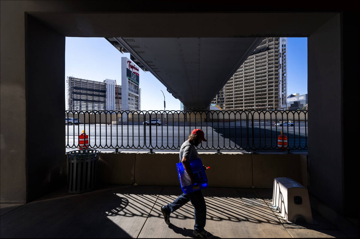 A man walks under the now closed pedestrian bridge from the MGM Grand as preparations for the u ...