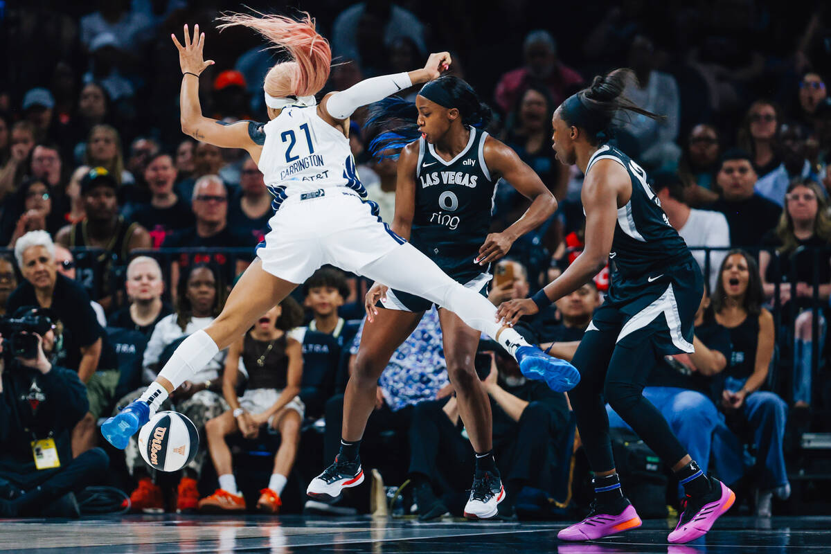 Dallas Wings guard DiJonai Carrington (21) and Las Vegas Aces guard Jackie Young (0) jump for t ...