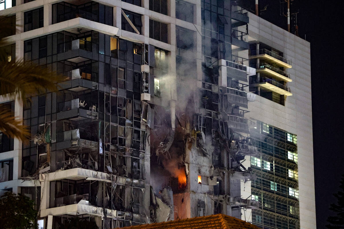 Fire and smoke rise from a building, reportedly hit by a missile fired from Iran, in central Te ...