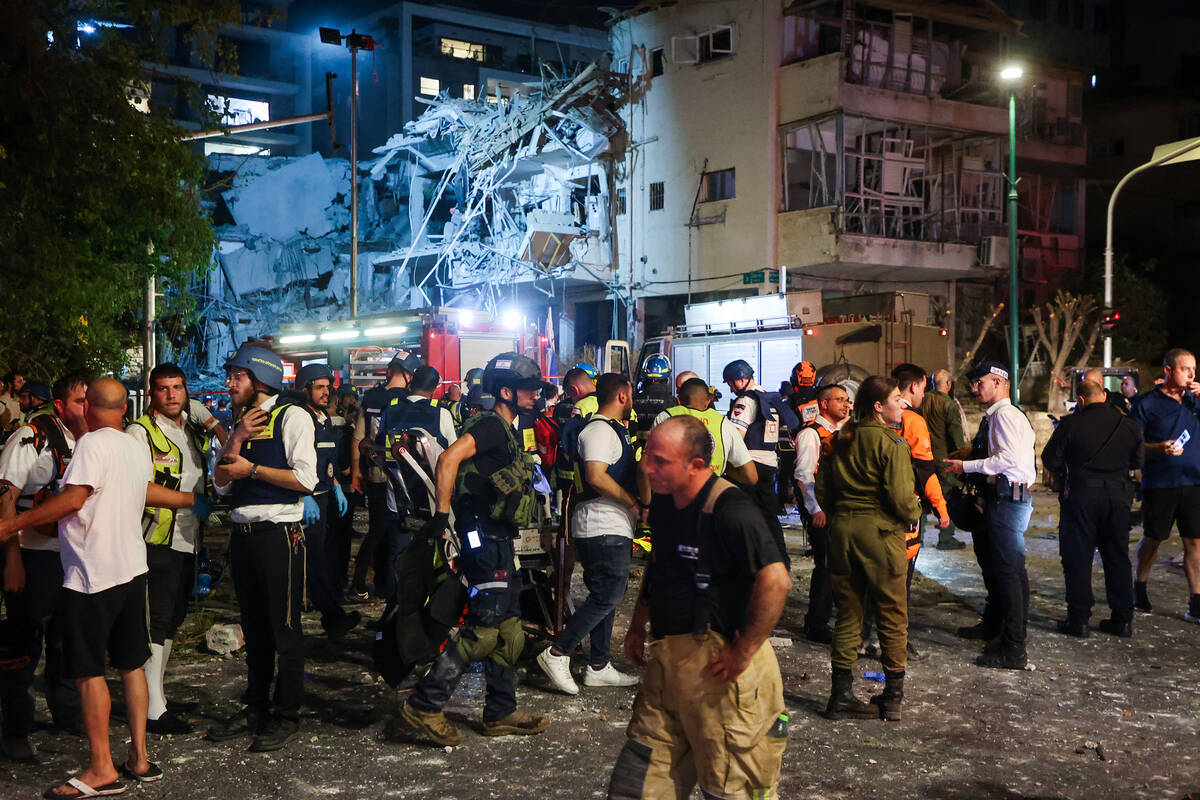 Israeli first responders arrive at a site hit by a missile fired from Iran, in Ramat Gan on the ...