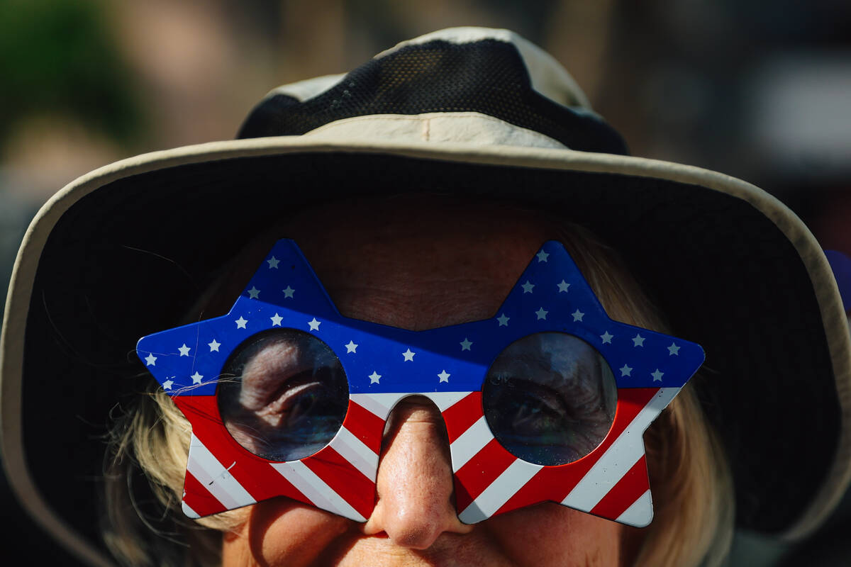 A protestor wears glasses during a national “No Kings” protest in the downtown ar ...