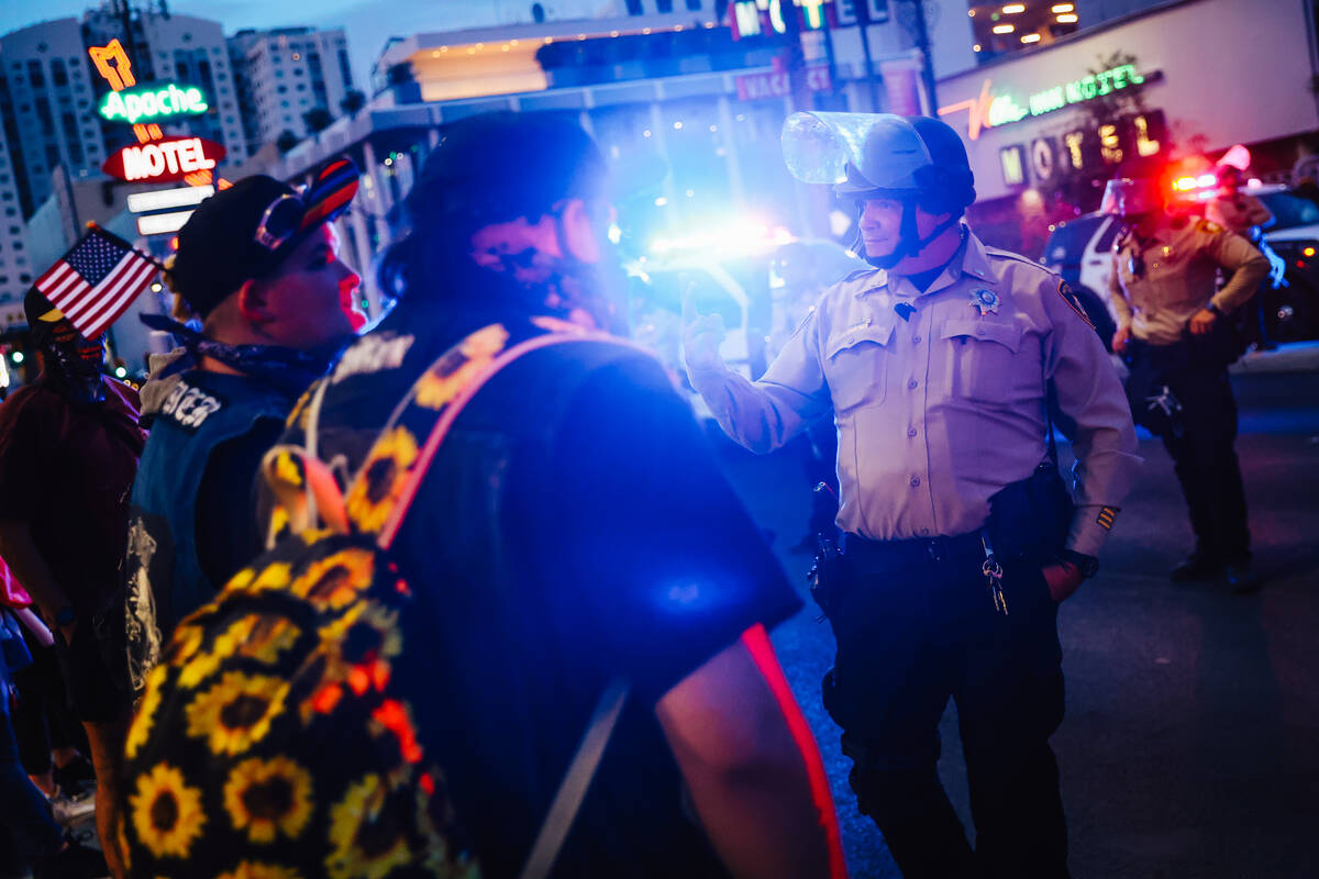 A metropolitan police officer gives the peace sign during a national “No Kings” p ...