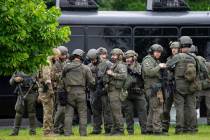 Law enforcement officers including local police, sheriffs and the FBI, stage less than a mile f ...