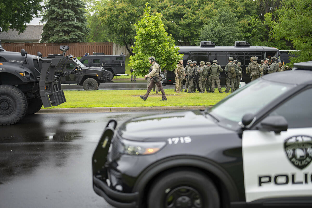 Law enforcement officers including local police, sheriffs and the FBI, stage less than a mile f ...
