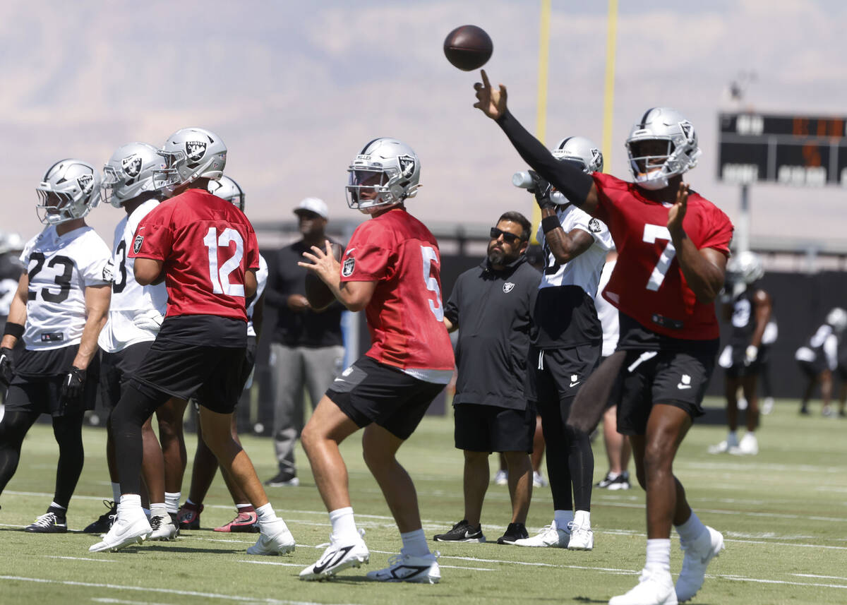 Raiders quarterback Geno Smith (7) throws the ball as quarterbacks Aidan O'Connell (12) and Ca ...