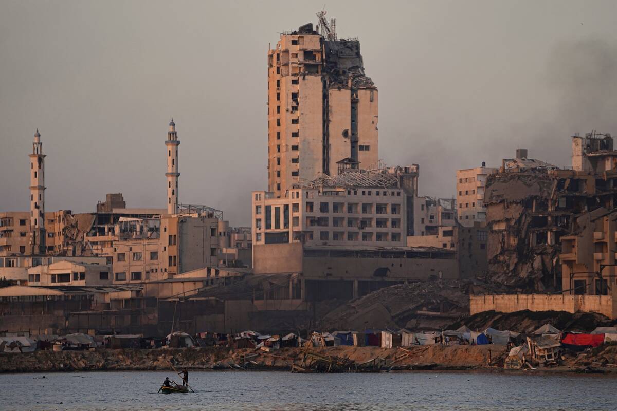 Two Palestinians ride a small boat at the seafront next to a tent camp in the Gaza City port, F ...