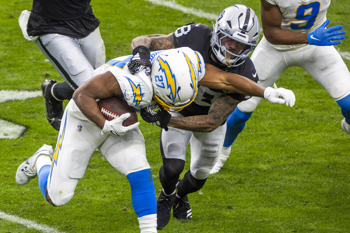 Los Angeles Chargers running back J.K. Dobbins (27) is tackled by Raiders cornerback Jack Jones ...