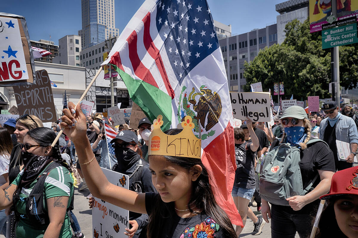 A young protester carries a combination Mexican and U.S. flag during a "No Kings" pro ...