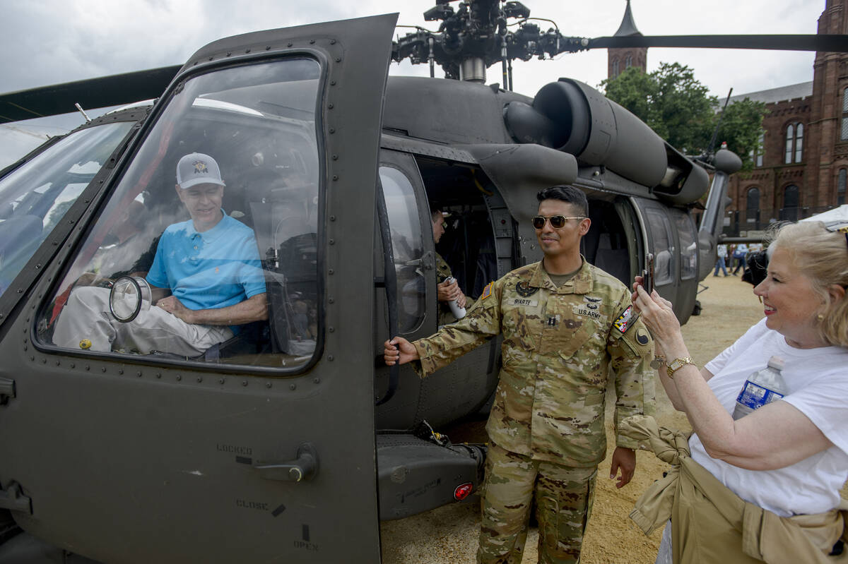 Dale Booth, left, of Tyler, Texas, poses in a Blackhawk helicopter for his wife Jan Booth, righ ...
