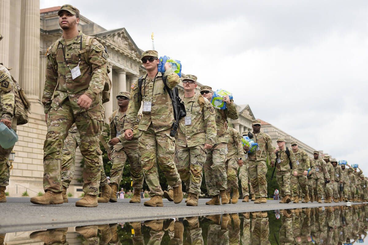 U.S. Army soldiers walking along Constitution Ave., on the National Mall ahead of a parade comm ...