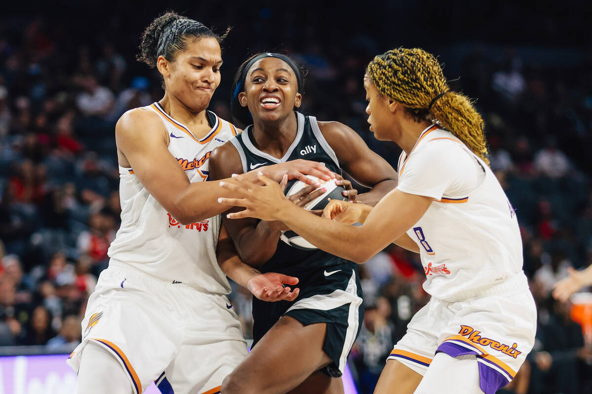 Aces guard Jackie Young (0) wrestles to get the ball out from Phoenix Mercury defense during a ...