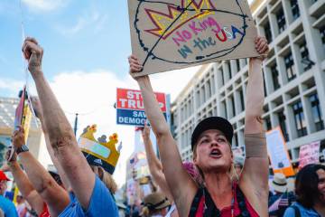Protestors shout during a national “No Kings” protest in the downtown area Saturd ...