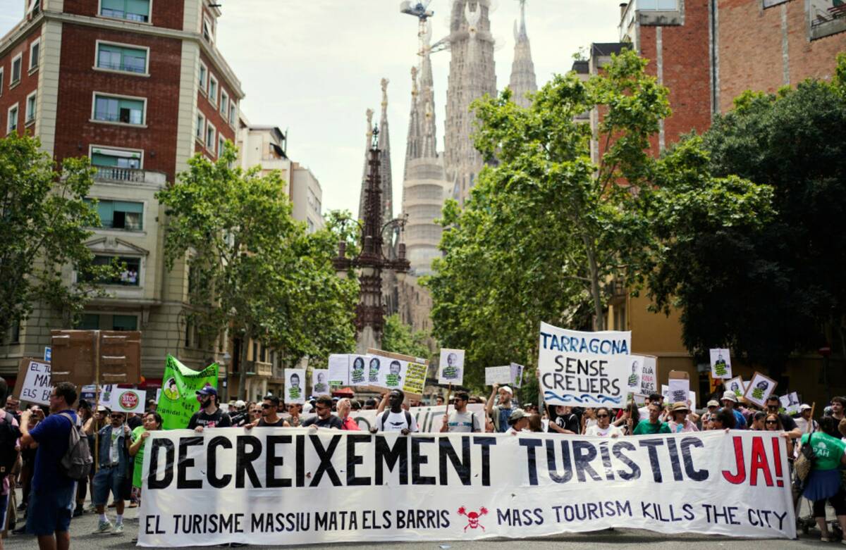People march near the Sagrada Familia basilica during a protest against overtourism in Barcelon ...