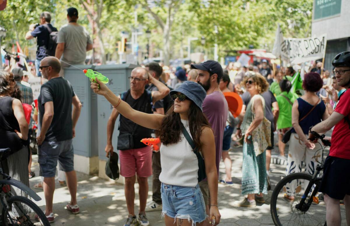 A protester shoots with a water gun while taking part in a protest against overtourism in Barce ...