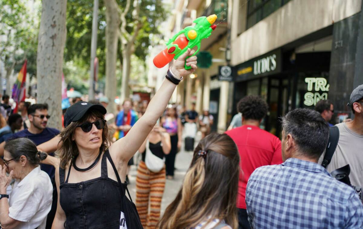 A protester with a water gun takes part in a protest against overtourism in Barcelona, Spain, S ...