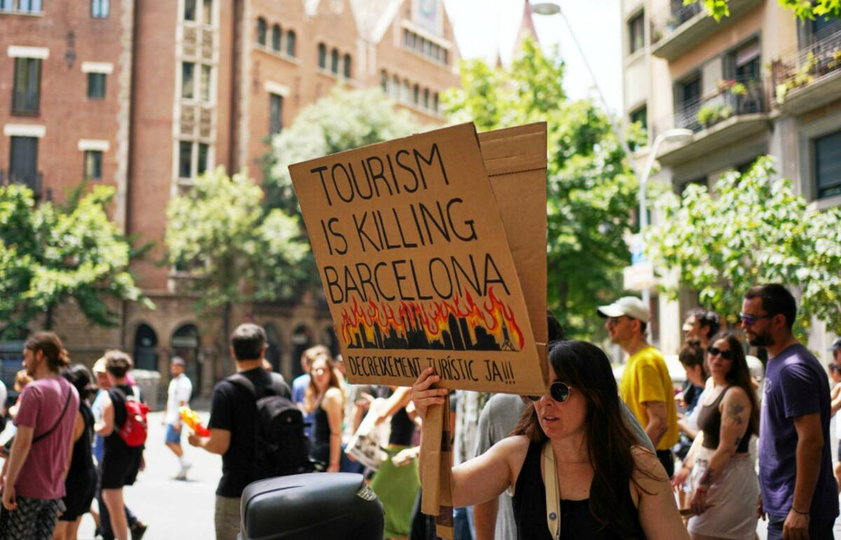 People march during a protest against overtourism in Barcelona, Spain, Sunday, June 15, 2025. ( ...