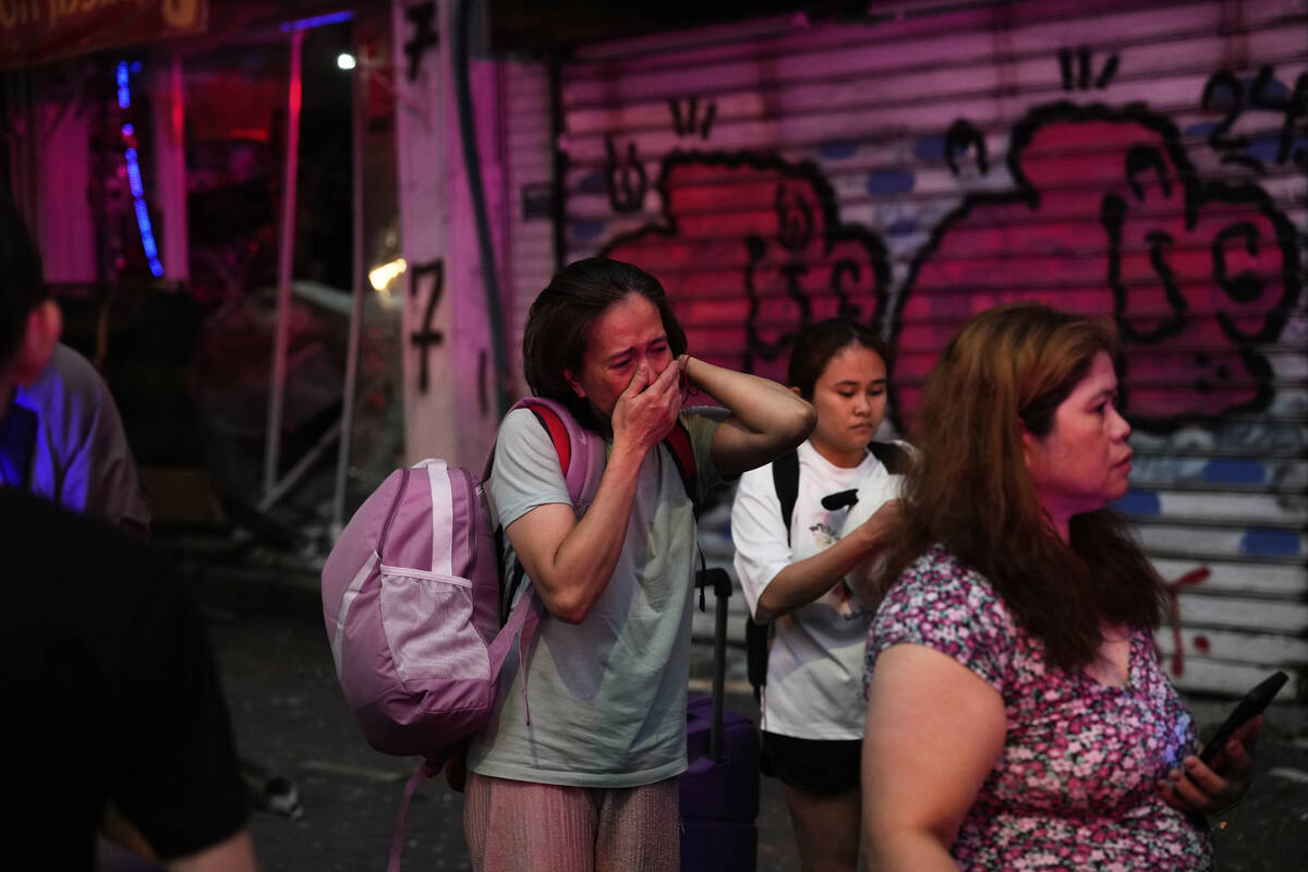 People evacuate after a missile launched from Iran struck Tel Aviv, Israel, Monday June 16, 202 ...