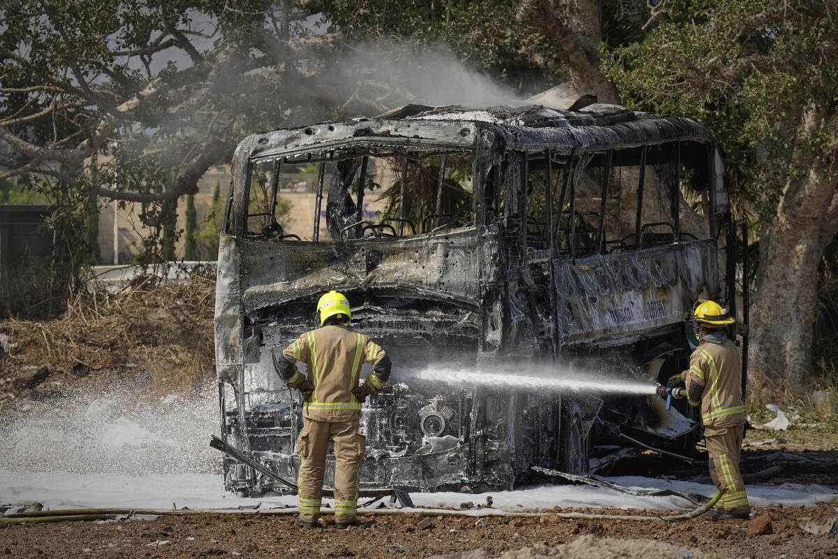 Firefighters work at site hit by a missile launched from Iran in central Israel on Tuesday, Jun ...