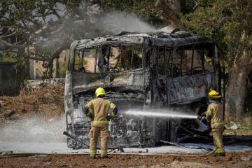 Firefighters work at site hit by a missile launched from Iran in central Israel on Tuesday, Jun ...