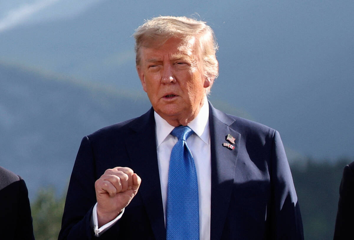 U.S. President Donald Trump gestures as he attends a family photo session during the G7 Summit, ...
