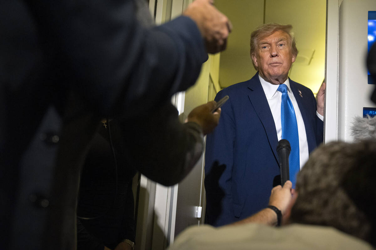 President Donald Trump speaks with reporters while flying aboard Air Force One en route from Ca ...
