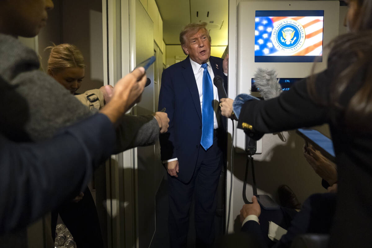 President Donald Trump speaks with reporters while flying aboard Air Force One en route from Ca ...