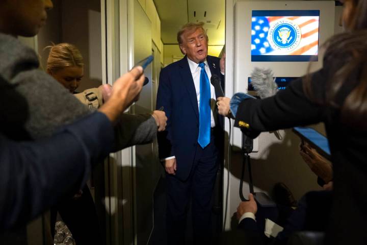 President Donald Trump speaks with reporters while flying aboard Air Force One en route from Ca ...