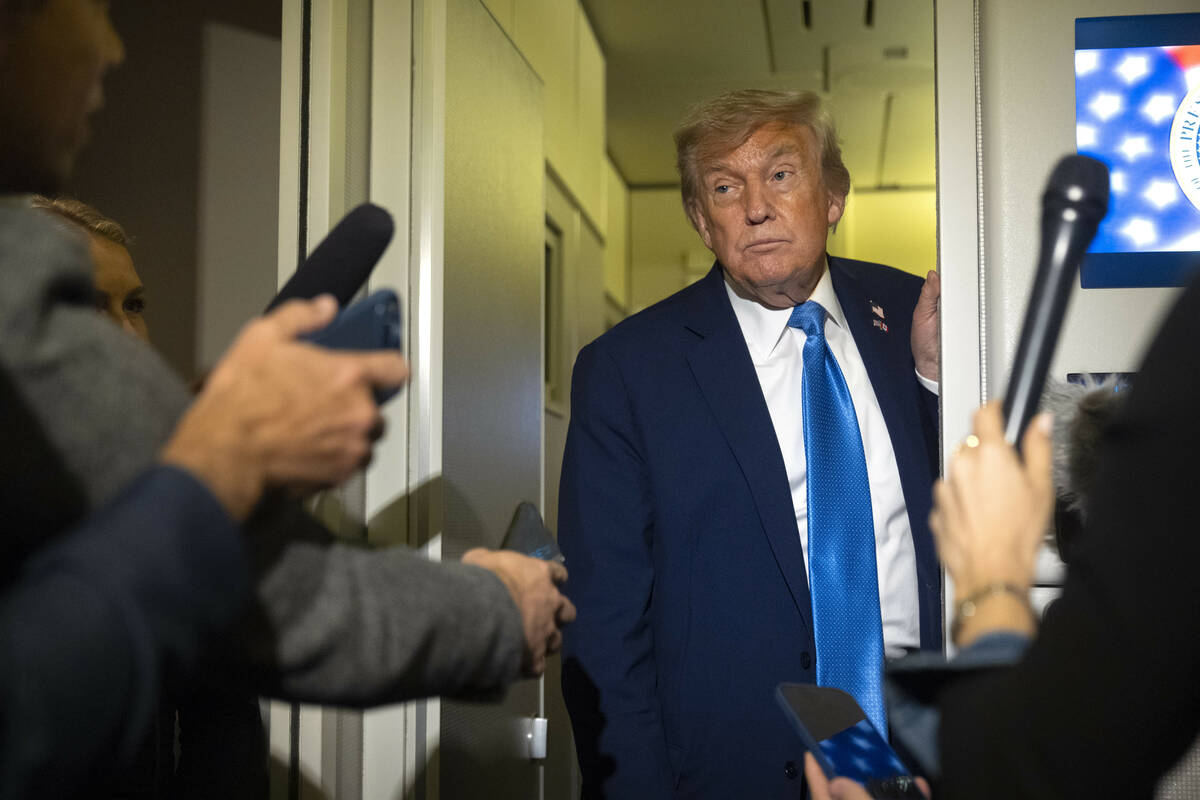 President Donald Trump speaks with reporters while flying aboard Air Force One en route from Ca ...