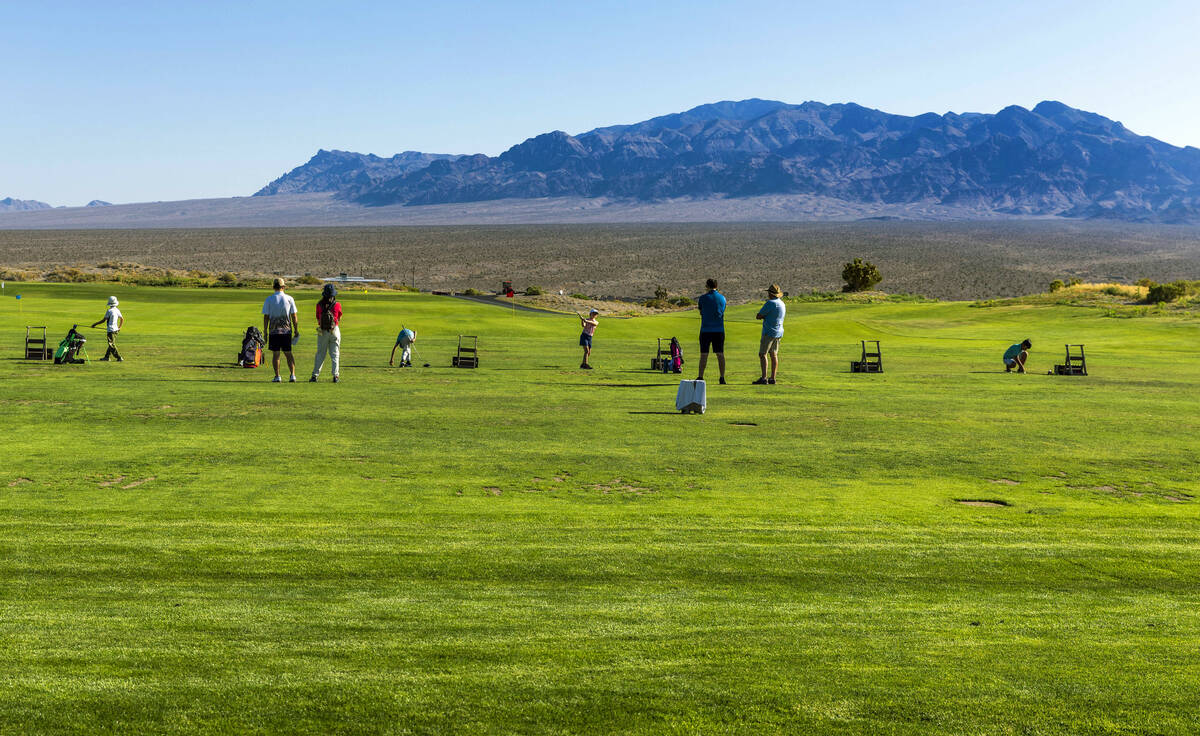 Golfers take some practice drives on the range awaiting their turns to compete during qualifyin ...