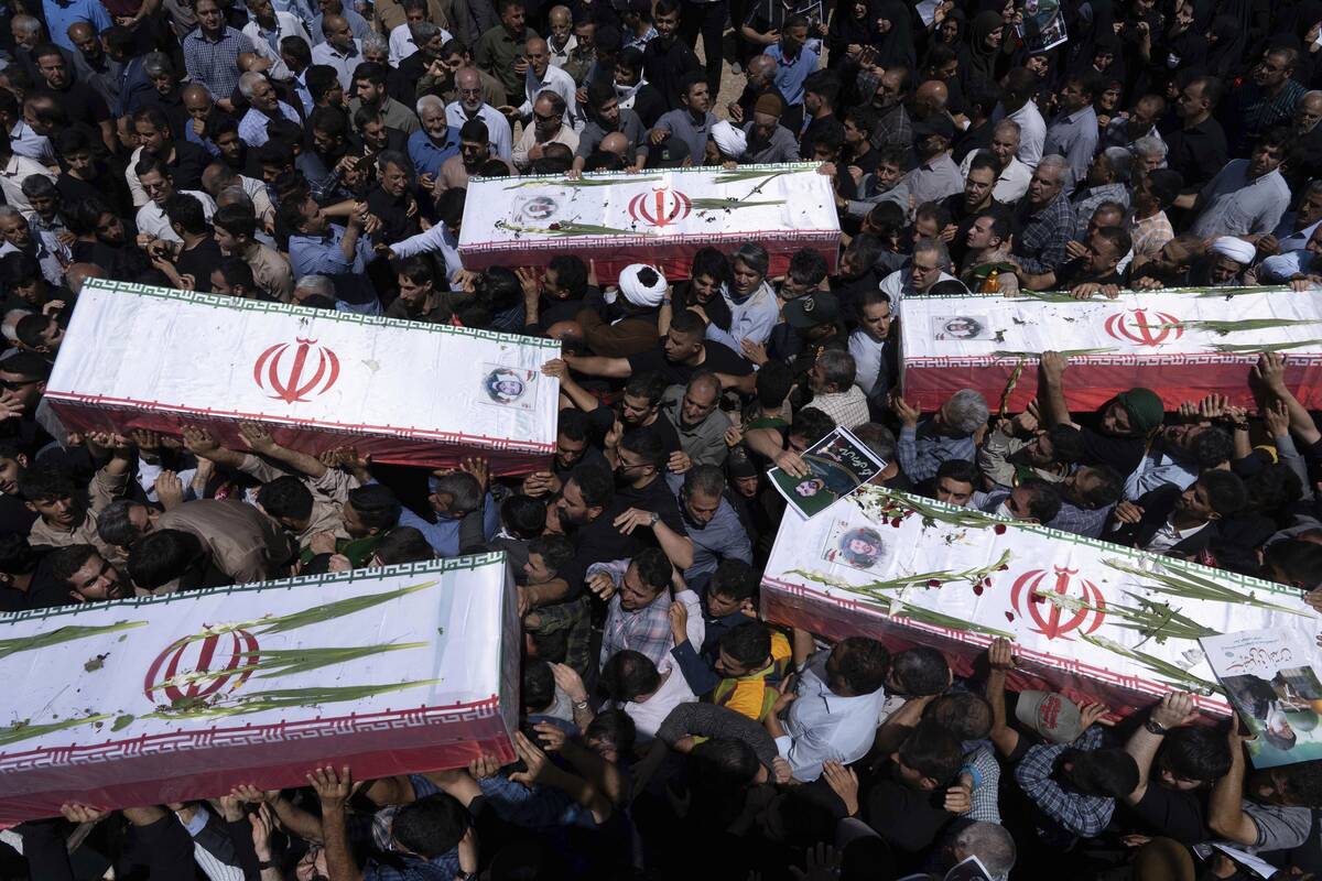 Mourners carry the flag-draped coffins of five men, whose names were not immediately available, ...