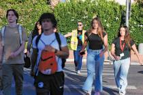 Ashley Brewer, center, a volunteer, helps students cross Buffalo Drive where McKenzie Scott, a ...