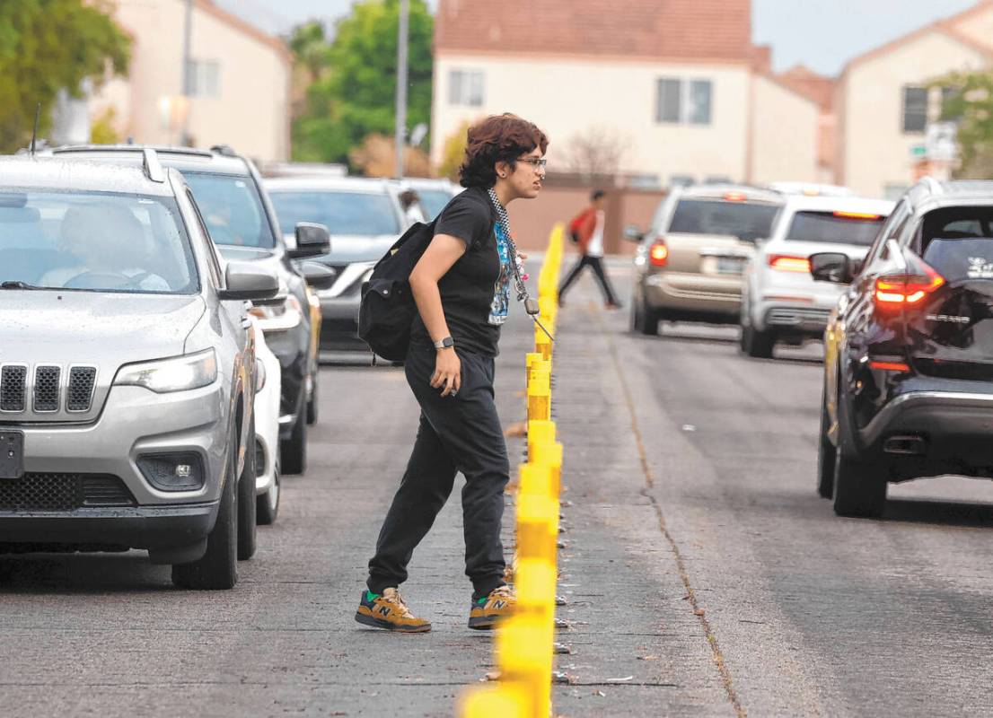 Arbor View High School student crosses Whispering Sands Drive as students are starting their fi ...