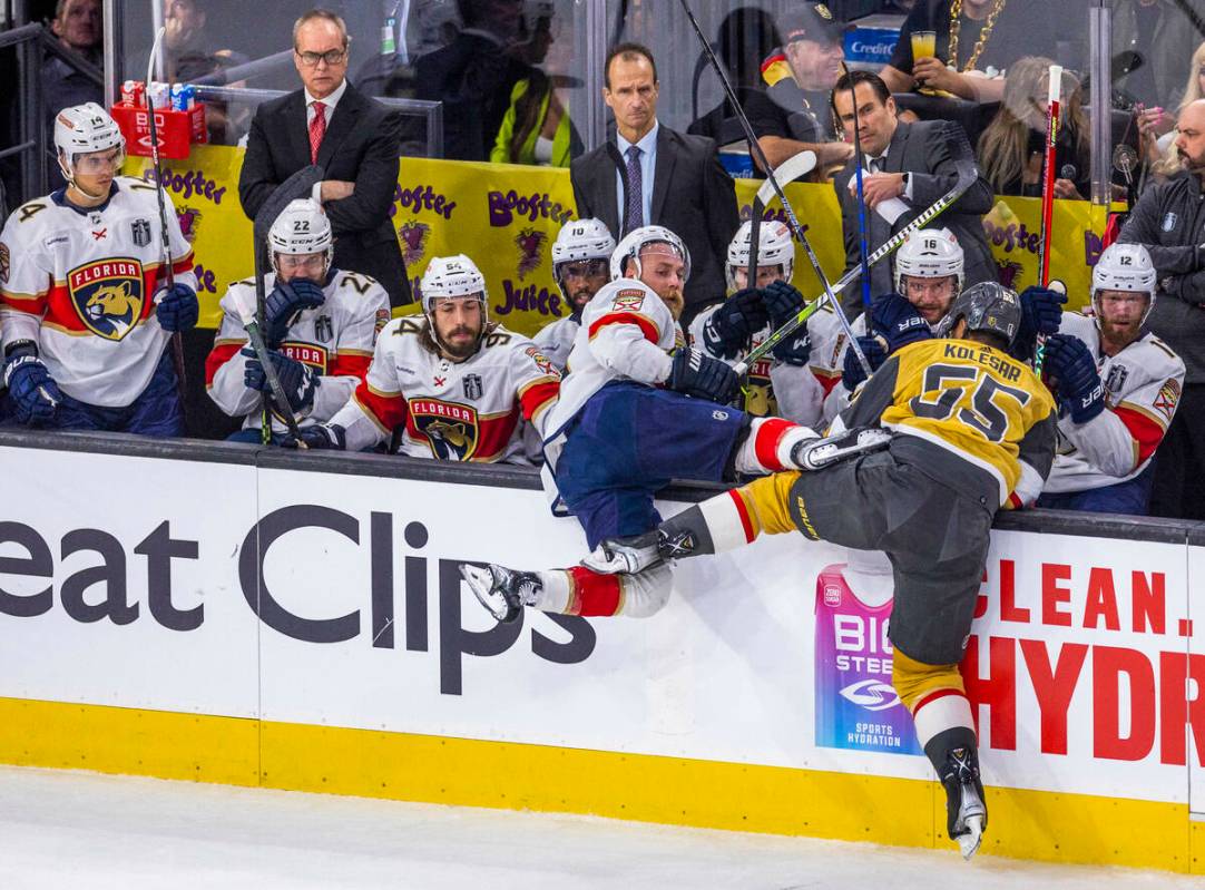 Florida Panthers defenseman Aaron Ekblad (5) is knocked into the bench by Golden Knights right ...