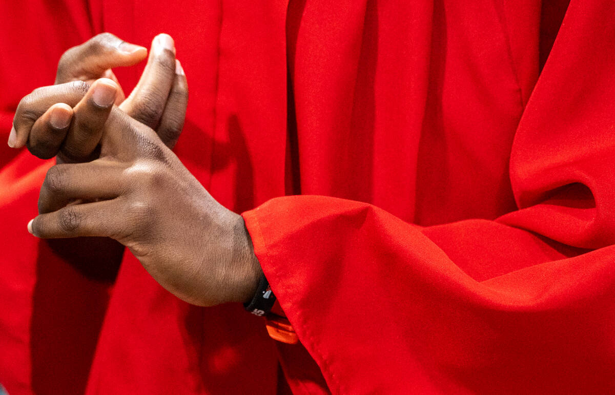 Isaiah Holliday, 18, waits to take a photo in his cap and gown during an open house event in La ...