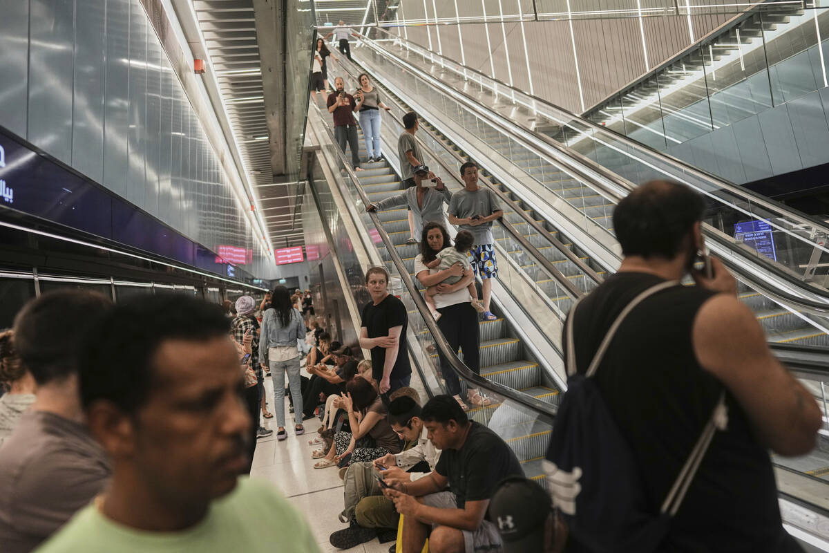 People shelter in an underground metro station as air raid sirens warn of incoming strikes by I ...