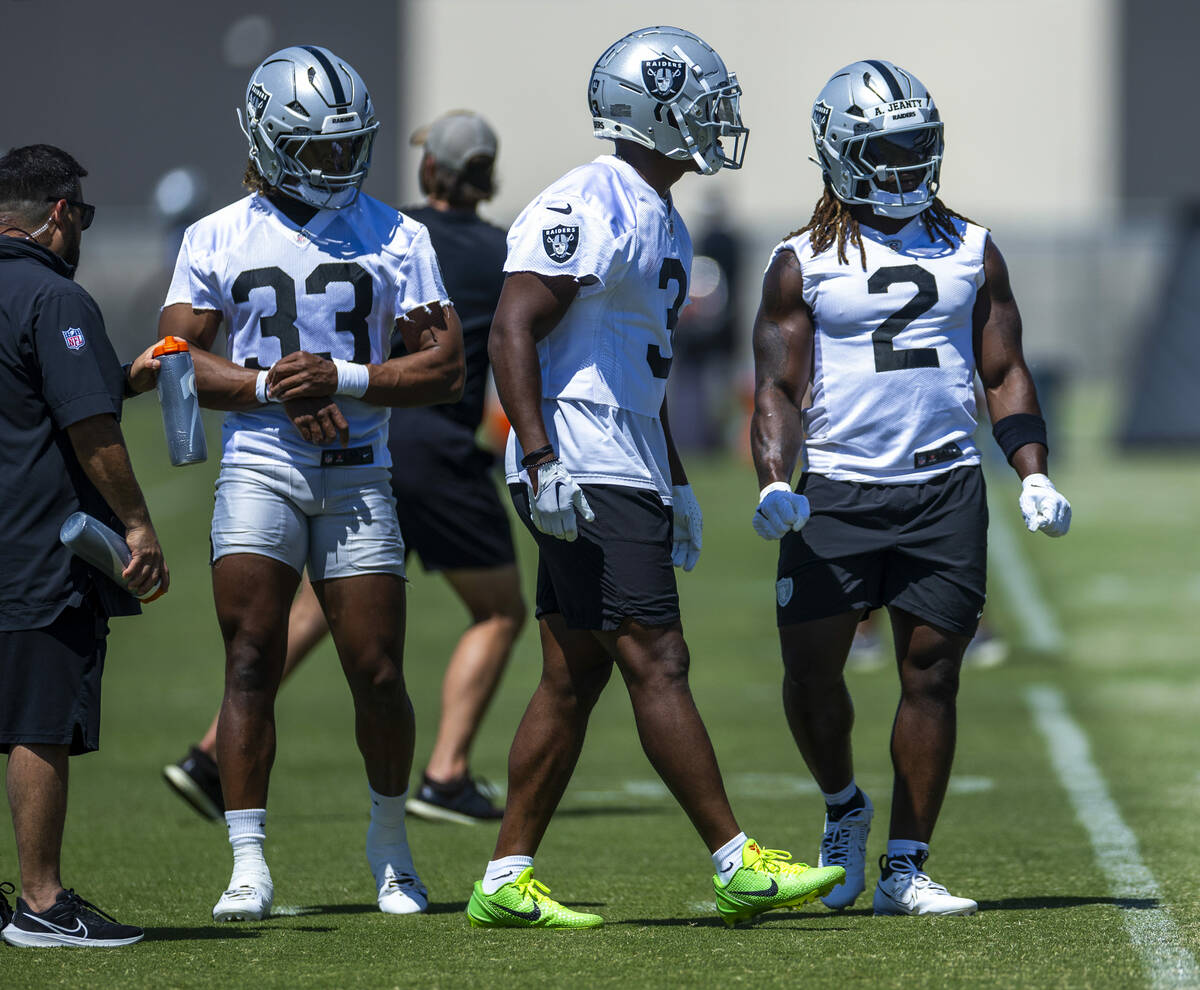 Raiders running backs Chris Collier (33), Zamir White (3) and Ashton Jeanty (2) watch teammates ...