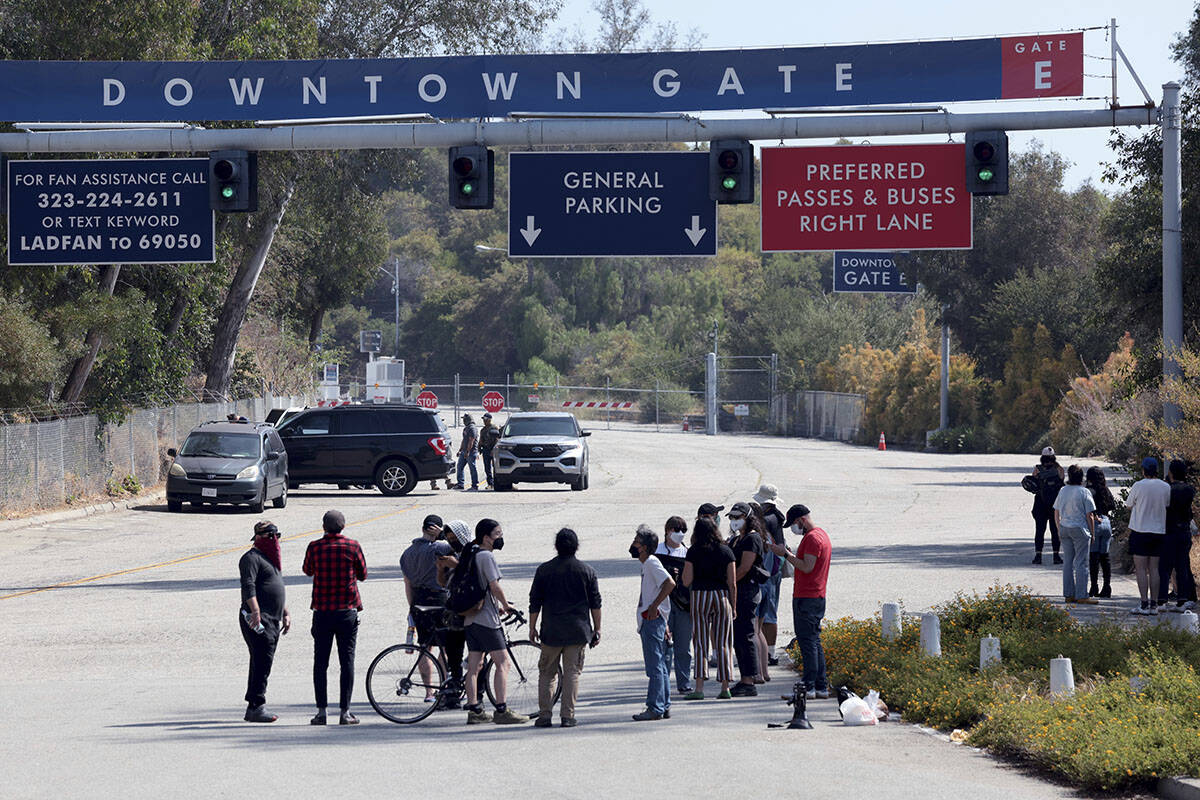 People watch as Immigration and Customs Enforcement agents stage outside Gate E of Dodger Stadi ...