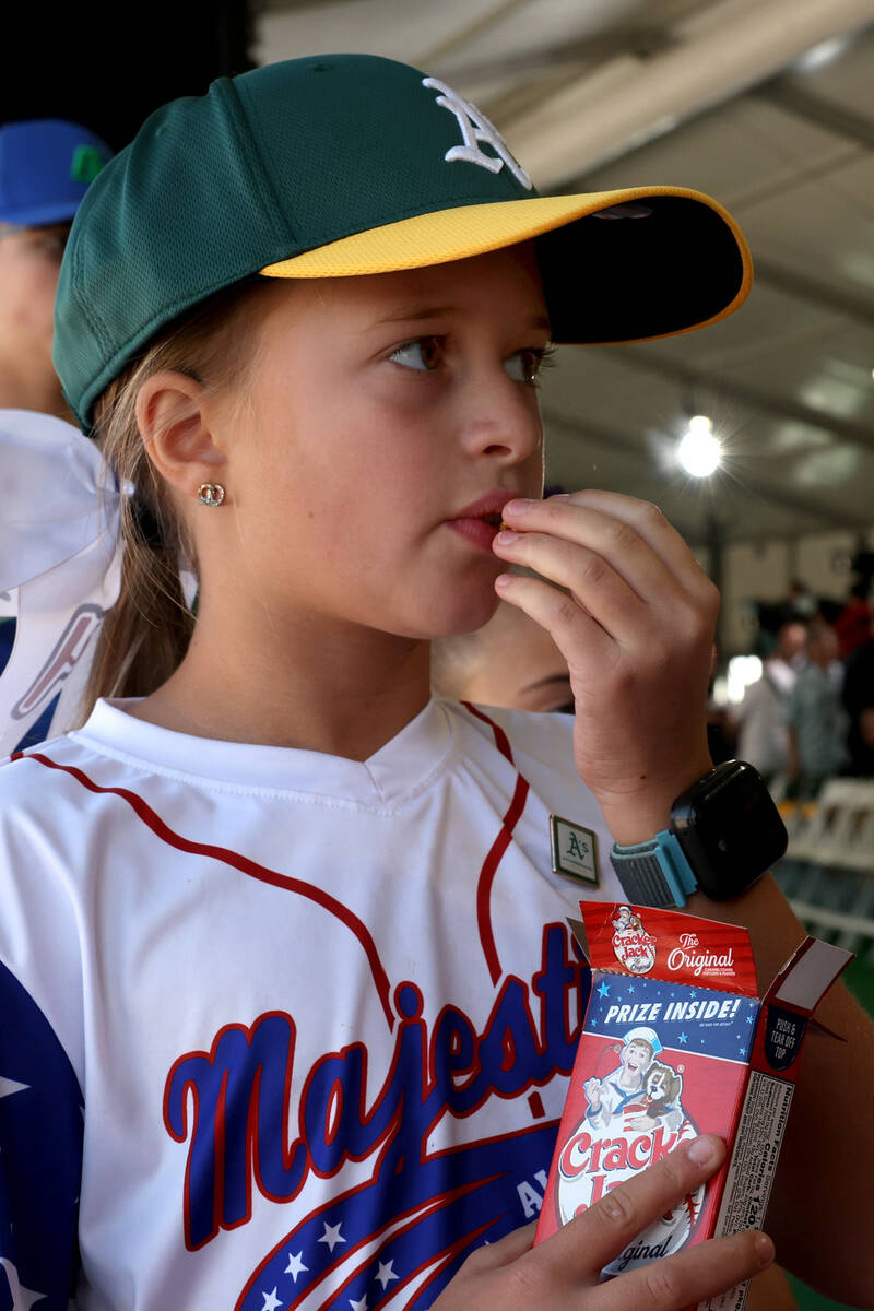 Little League softball player Ramona Peters, 8, eats Cracker Jack during a groundbreaking cerem ...