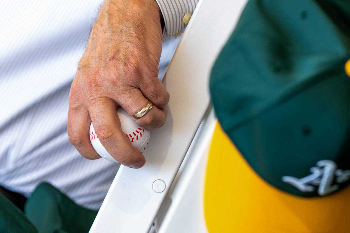 A guest holds a soft baseball given out as gifts during the groundbreaking ceremony for the Ath ...