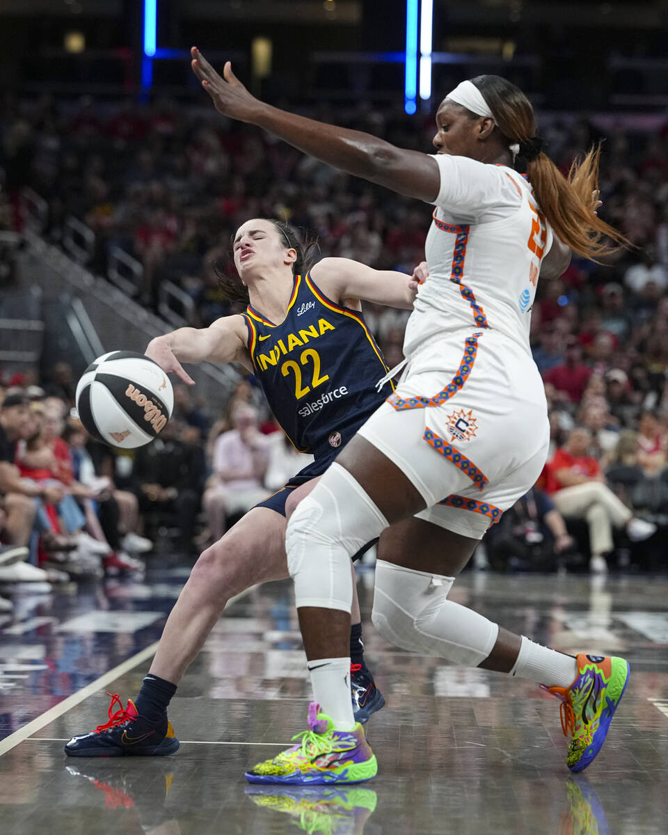 Indiana Fever guard Caitlin Clark (22) is fouled by Connecticut Sun center Kariata Diaby (23) i ...