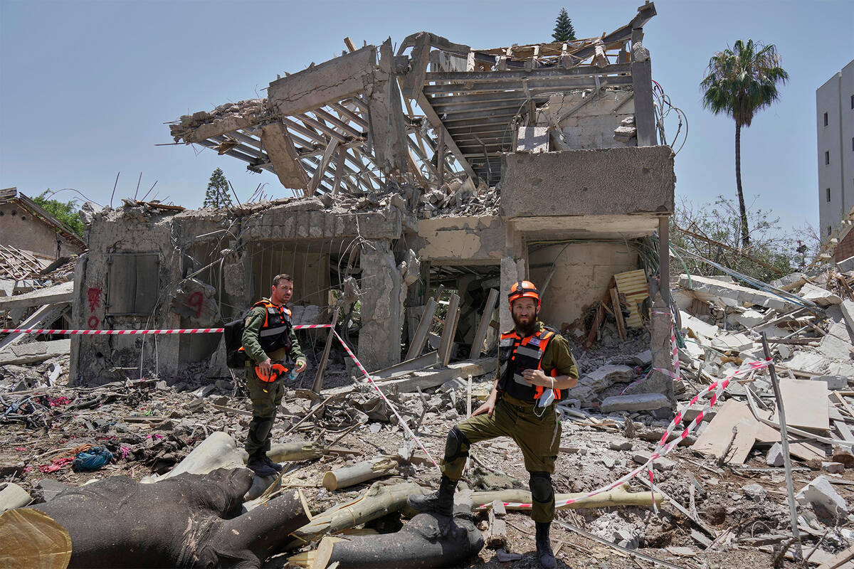 Israeli soldiers inspect the site struck by a direct missile strike launched from Iran in Tel A ...