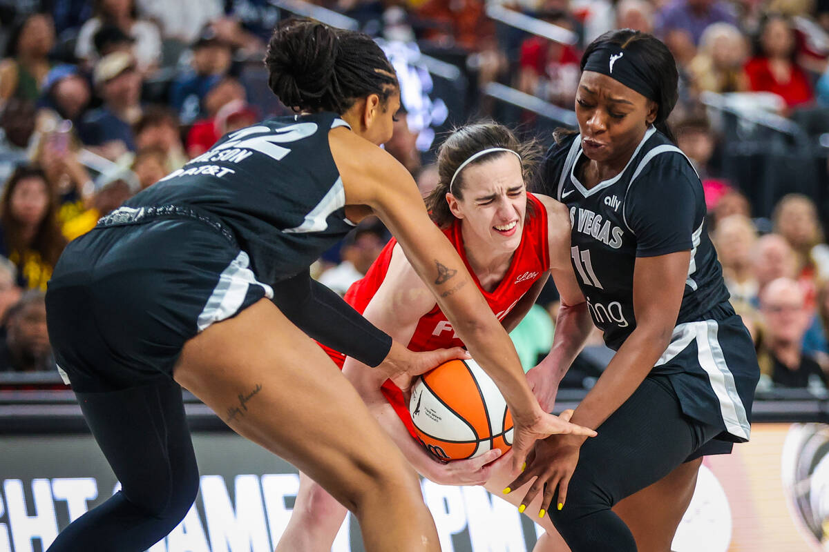Indiana Fever guard Caitlin Clark (22) is sandwiched by Aces defense during a WNBA basketball g ...