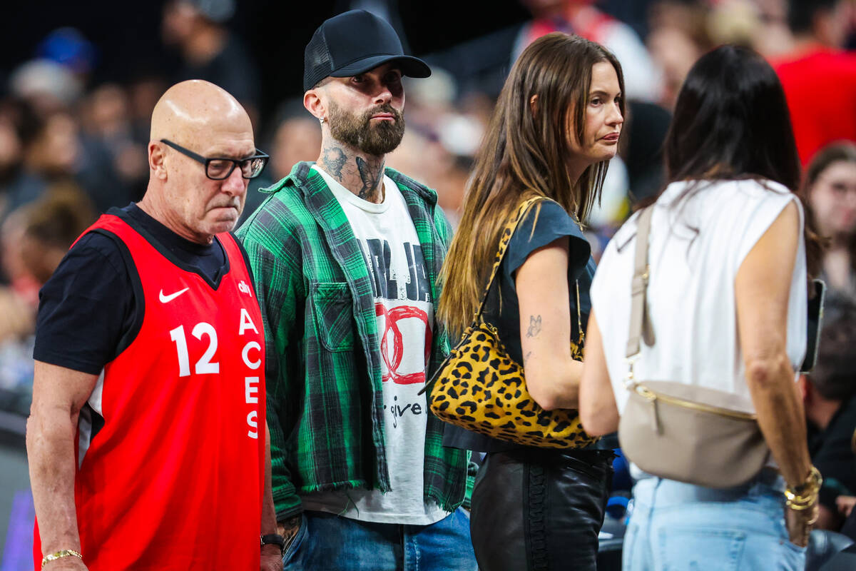 Maroon 5 frontman Adam Levine, second from left, stands courtside during a WNBA basketball game ...