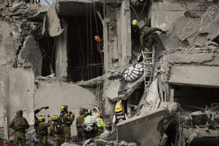 Israeli soldiers and rescue team work amid the rubble of residential buildings destroyed by an ...