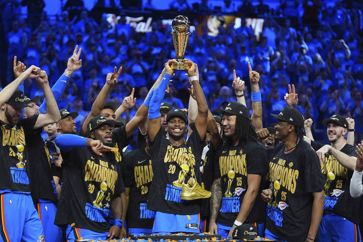 Oklahoma City Thunder guard Shai Gilgeous-Alexander, center, holds up the MVP trophy as he cele ...