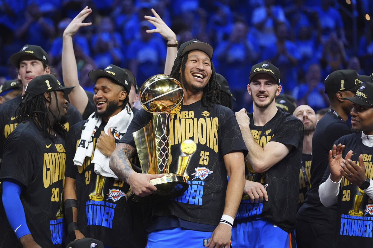Oklahoma City Thunder forward Jaylin Williams holds the Larry O'Brien Championship Trophy as he ...